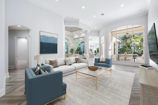 living room with an inviting chandelier, crown molding, and parquet floors