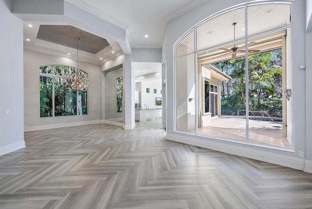 foyer entrance with ceiling fan, plenty of natural light, ornamental molding, and light parquet floors