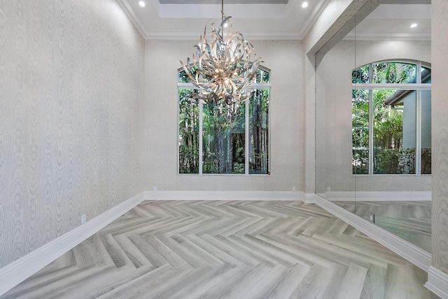 empty room with a notable chandelier, ornamental molding, and light parquet flooring