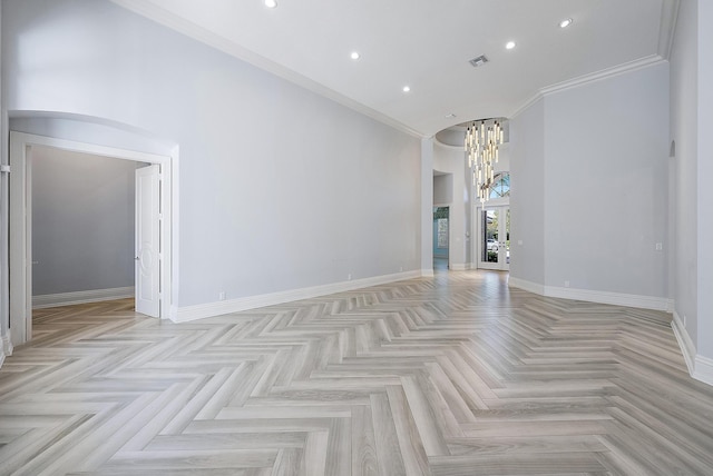 unfurnished room with ornamental molding, light parquet flooring, and an inviting chandelier