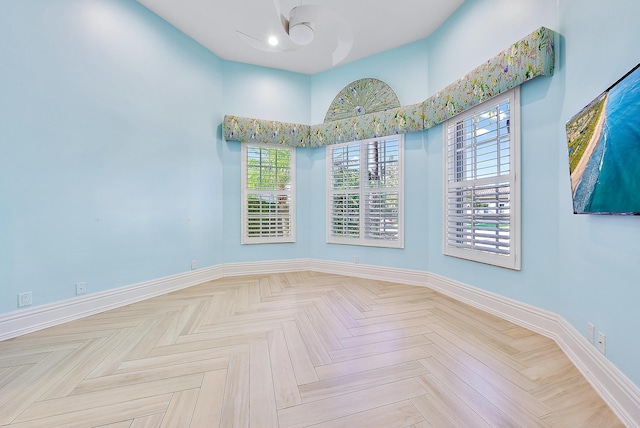 empty room featuring a towering ceiling and light parquet floors