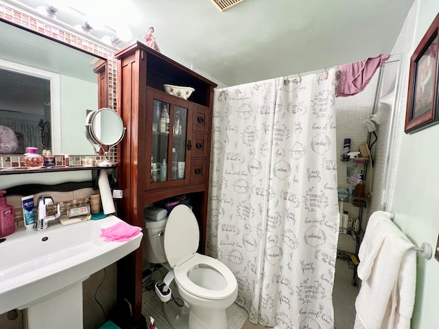 bathroom with tile patterned floors, a shower with curtain, toilet, and sink