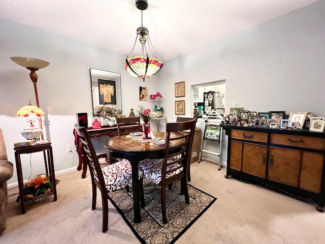 carpeted dining room featuring a textured ceiling