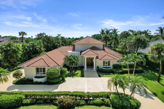 mediterranean / spanish home featuring a front lawn