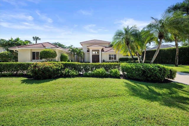 mediterranean / spanish home with a front lawn