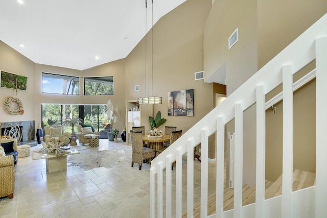 stairs featuring a towering ceiling and a high end fireplace