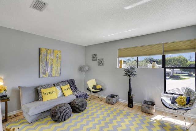 sitting room with light hardwood / wood-style flooring and a textured ceiling