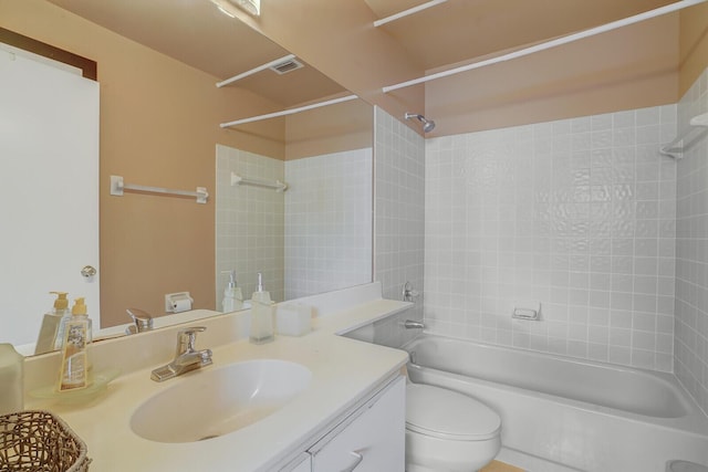 full bathroom featuring tiled shower / bath combo, vanity, and toilet