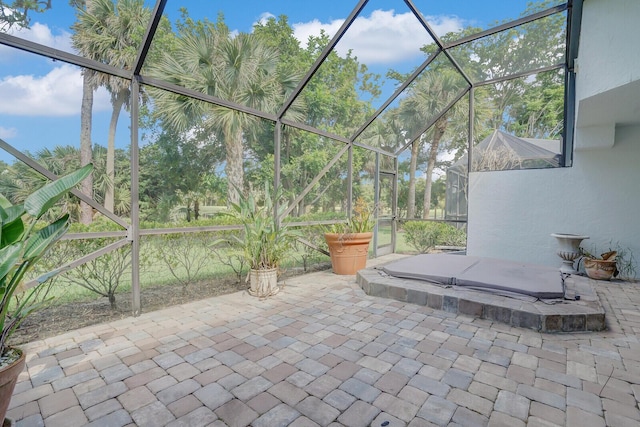 view of patio featuring a lanai and a covered hot tub