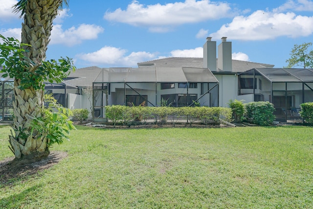 back of house featuring a yard and a lanai