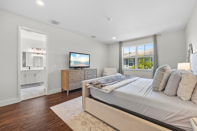 bedroom with ensuite bath and dark hardwood / wood-style flooring