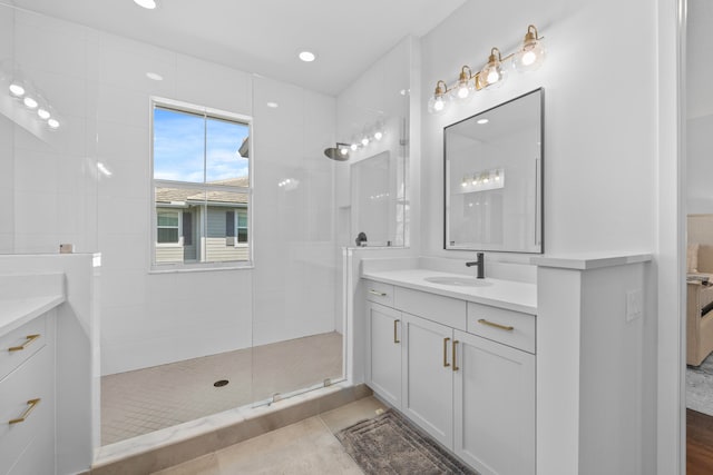 bathroom with tile patterned floors, vanity, and a tile shower