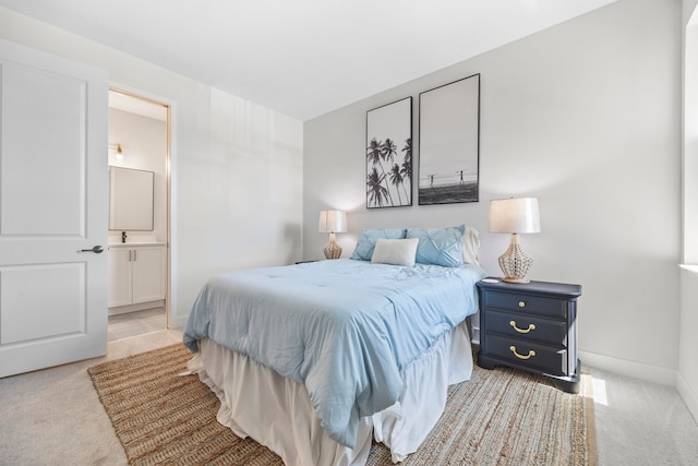 bedroom with connected bathroom and light colored carpet