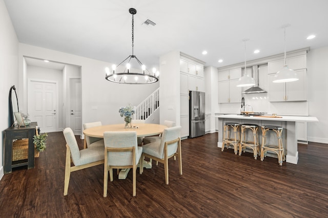 dining area with dark hardwood / wood-style floors and a notable chandelier