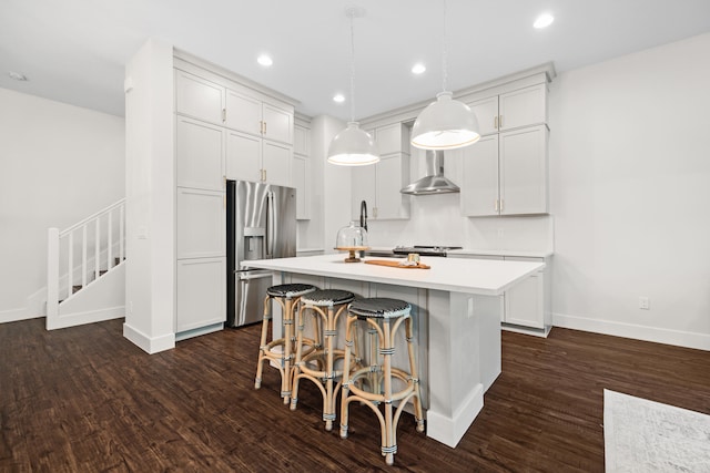 kitchen with stainless steel fridge, pendant lighting, dark hardwood / wood-style flooring, and a kitchen island with sink