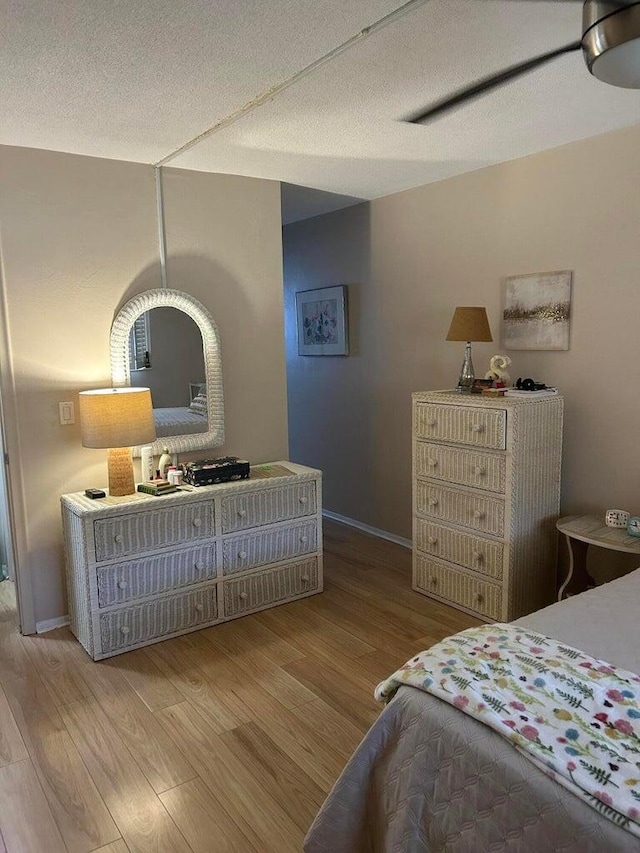 bedroom with a textured ceiling and light hardwood / wood-style flooring