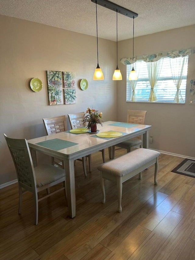 dining room with dark wood-type flooring and a textured ceiling