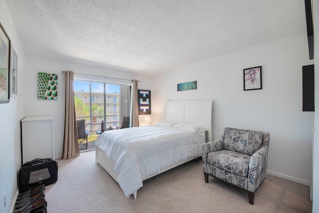 bedroom with light colored carpet, a textured ceiling, and access to exterior