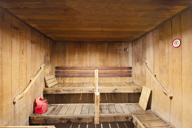 view of sauna / steam room featuring wood ceiling and wooden walls