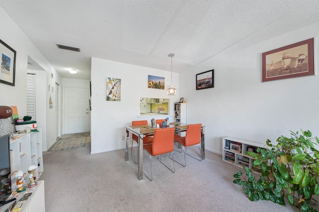 2581 N Garden Dr Unit 306, Lake Worth, FL 33461 - dining room with carpet flooring, a textured ceiling, a chandelier, and baseboards