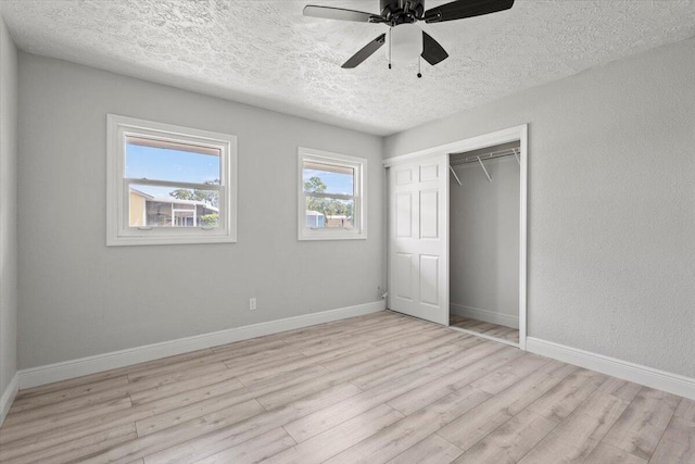 unfurnished bedroom with a closet, ceiling fan, light hardwood / wood-style flooring, and a textured ceiling