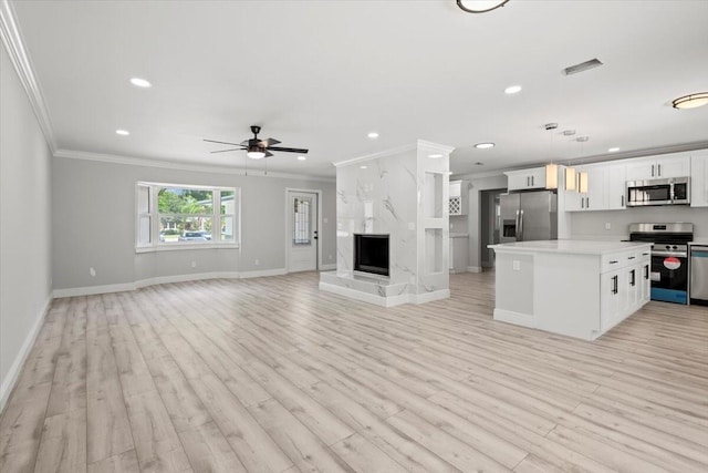 kitchen with white cabinetry, hanging light fixtures, light hardwood / wood-style floors, and appliances with stainless steel finishes