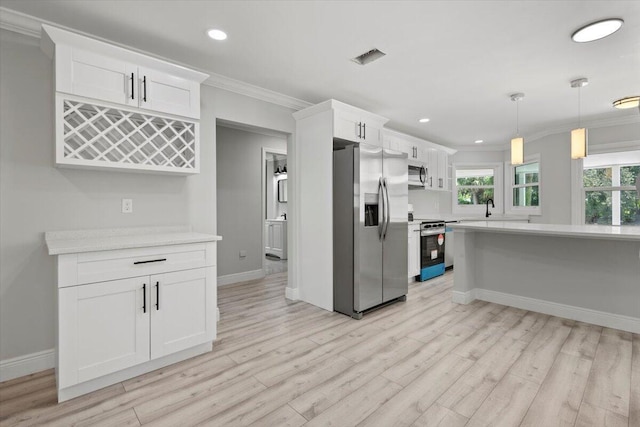 kitchen with white cabinets, light wood-type flooring, stainless steel appliances, and ornamental molding