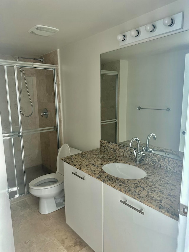 bathroom featuring vanity, toilet, and an enclosed shower