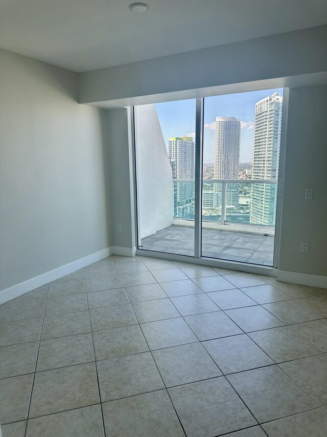 41 SE 5th St Unit 2017, Miami, FL 33131 - spare room with tile patterned flooring, a city view, and baseboards