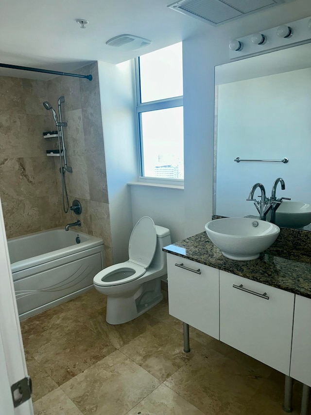 full bathroom with vanity, toilet, and tiled shower / bath