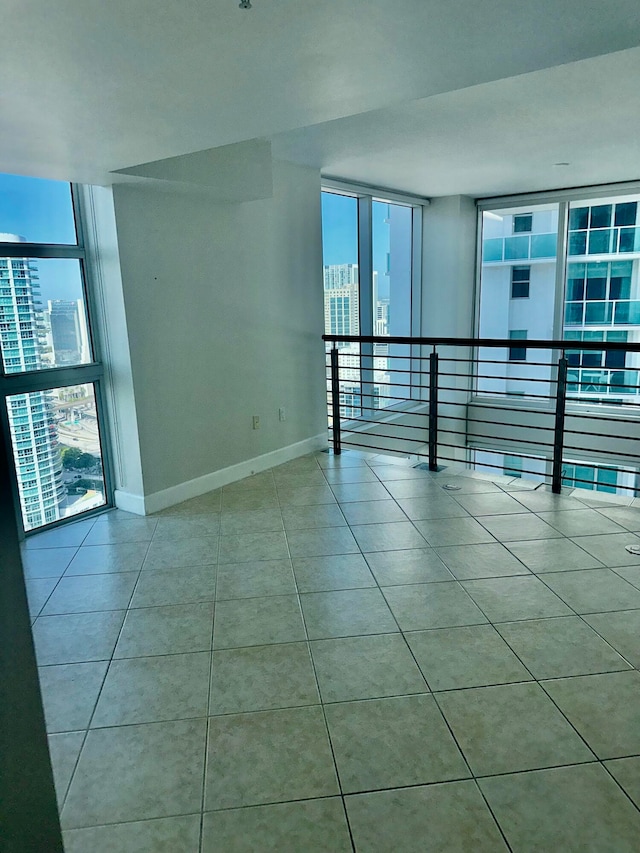 tiled empty room featuring expansive windows and a healthy amount of sunlight