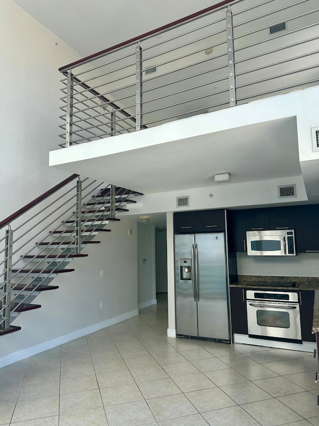 kitchen featuring stainless steel appliances and light tile patterned flooring