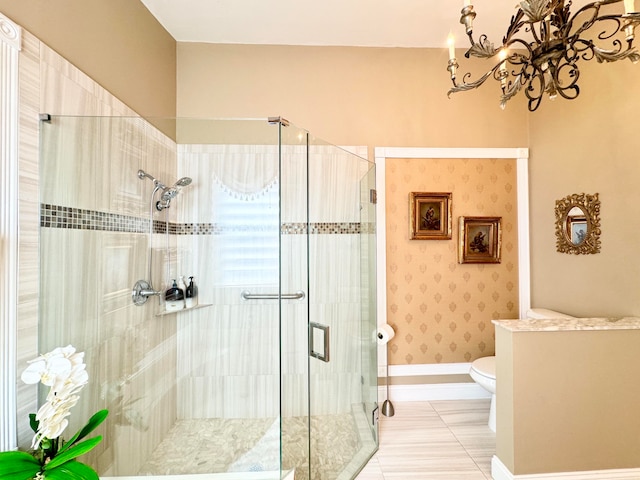 bathroom featuring tile patterned floors, a shower with shower door, a notable chandelier, and toilet