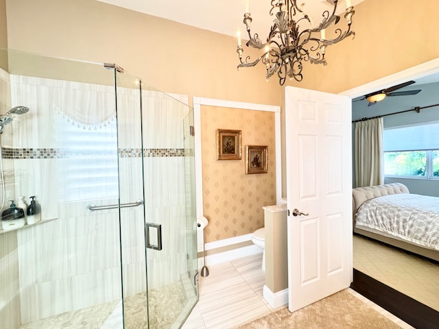 bathroom with ceiling fan with notable chandelier, toilet, and a shower with shower door