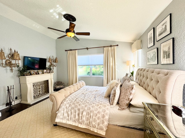 bedroom with ceiling fan, a textured ceiling, and vaulted ceiling