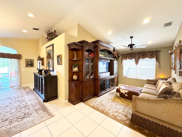 living room with ceiling fan, light tile patterned flooring, and vaulted ceiling