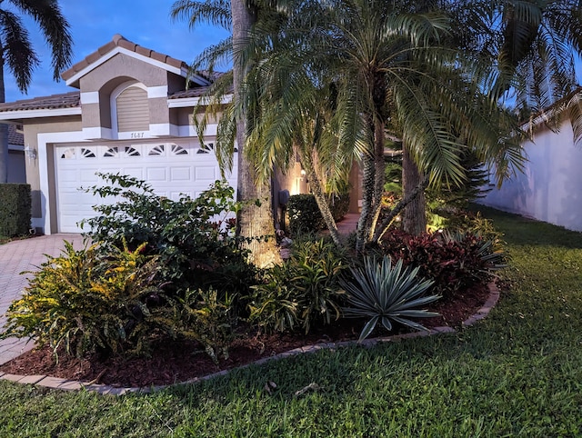 view of front of house featuring a front lawn and a garage