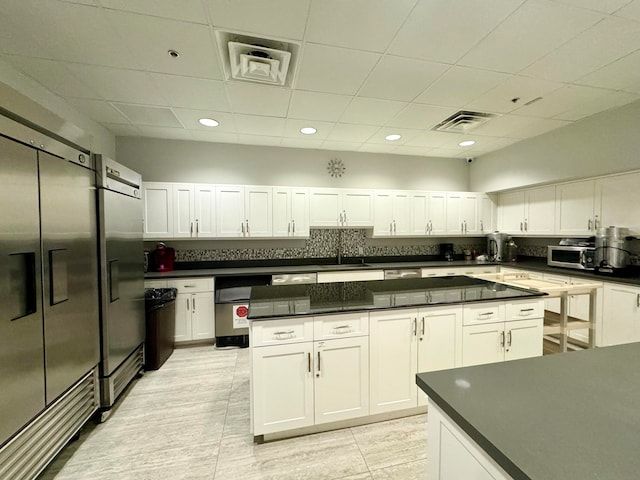 kitchen with stainless steel fridge with ice dispenser, a center island, and white cabinets