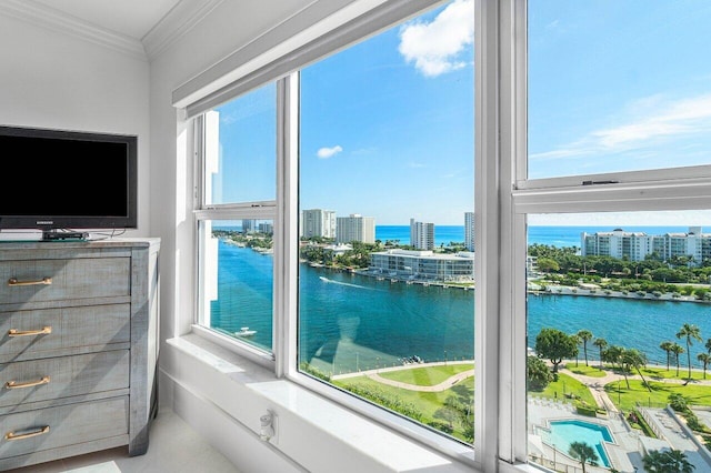 interior space with a water view, multiple windows, and crown molding