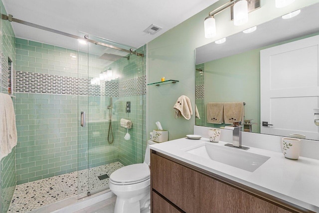 bathroom featuring vanity, toilet, and an enclosed shower