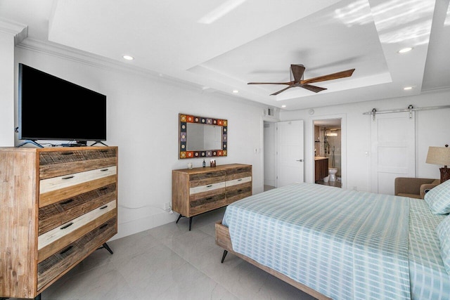 bedroom featuring a tray ceiling, a barn door, connected bathroom, crown molding, and ceiling fan