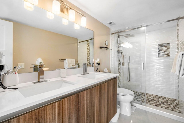 bathroom with vanity, toilet, and a shower with door