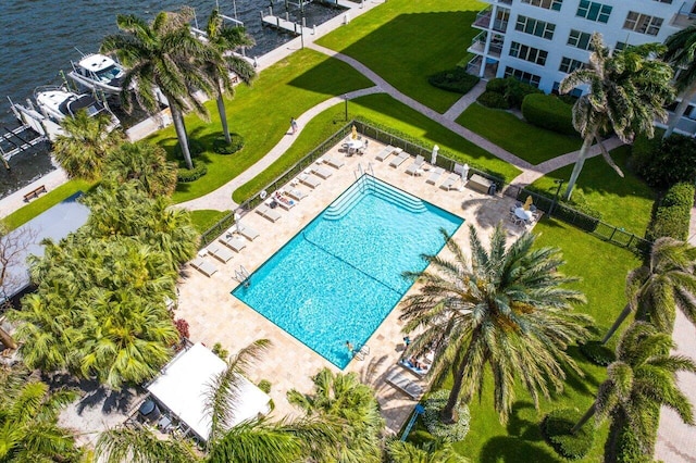 view of pool featuring a water view, a yard, and a patio area