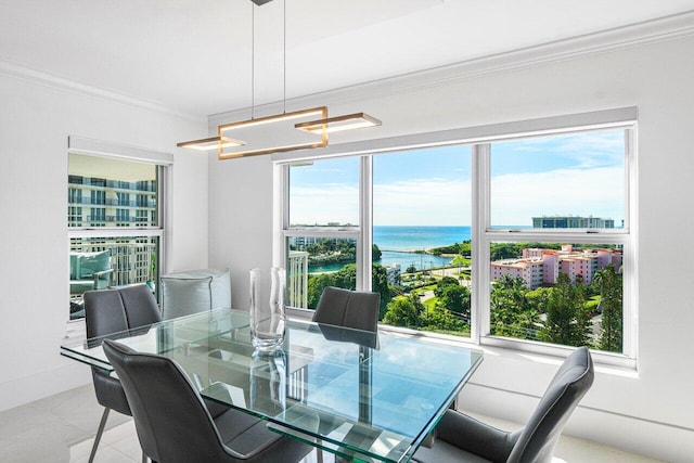 tiled dining space featuring a water view, a chandelier, and crown molding