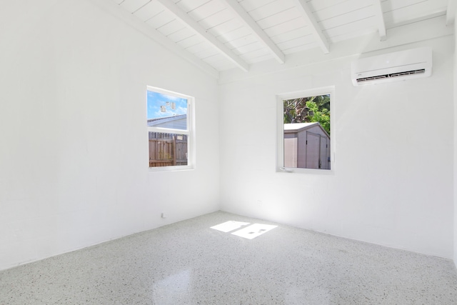 unfurnished room with vaulted ceiling with beams, an AC wall unit, and plenty of natural light