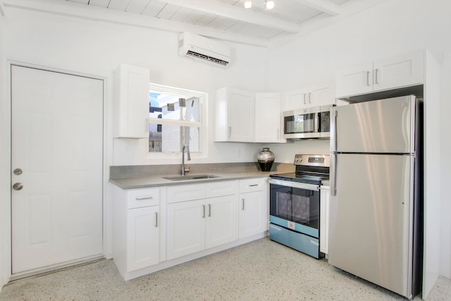 kitchen featuring appliances with stainless steel finishes, white cabinetry, beam ceiling, and a wall mounted air conditioner