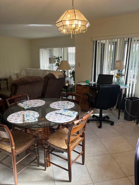 dining area with light tile patterned floors and an inviting chandelier