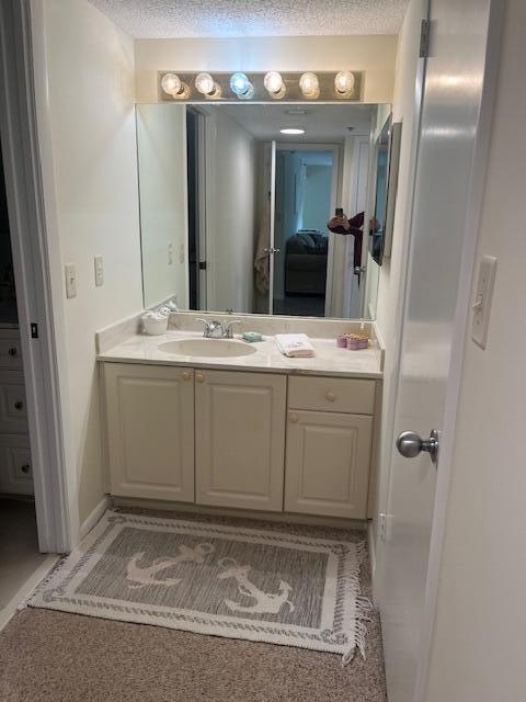 bathroom with a textured ceiling, vanity, and tile patterned floors