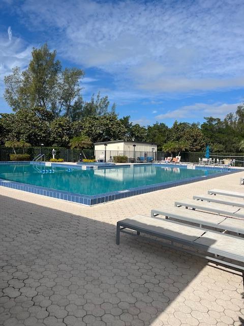 pool with a patio area and fence