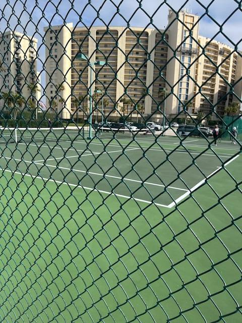 view of tennis court featuring fence